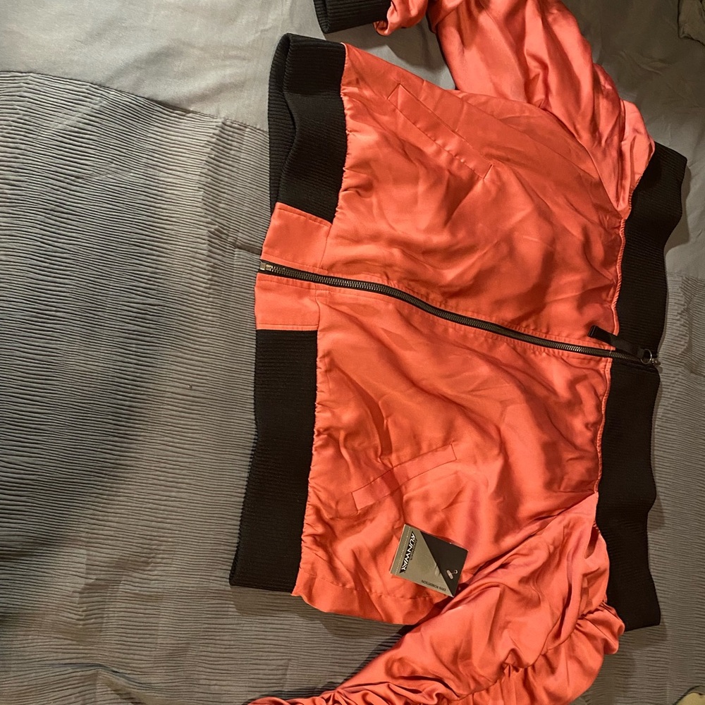 Off the shoulder, satin jacket with a black trim.